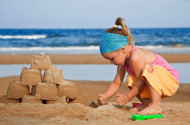 child o the beach building a sandcastle