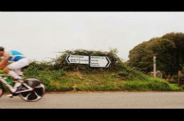 Ironman cyclist zooming past Pembrokeshire road signs