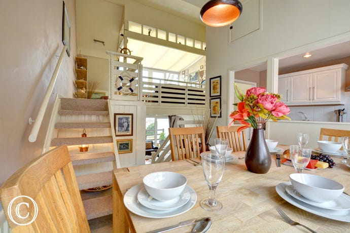 View of the kitchen from the dining area, stairs upto additional seating area