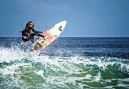 Woman on surfboard riding a wave